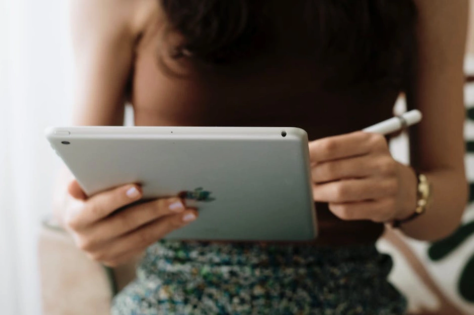 Uživatel prochází online knihovnu finančních článků na tabletu.